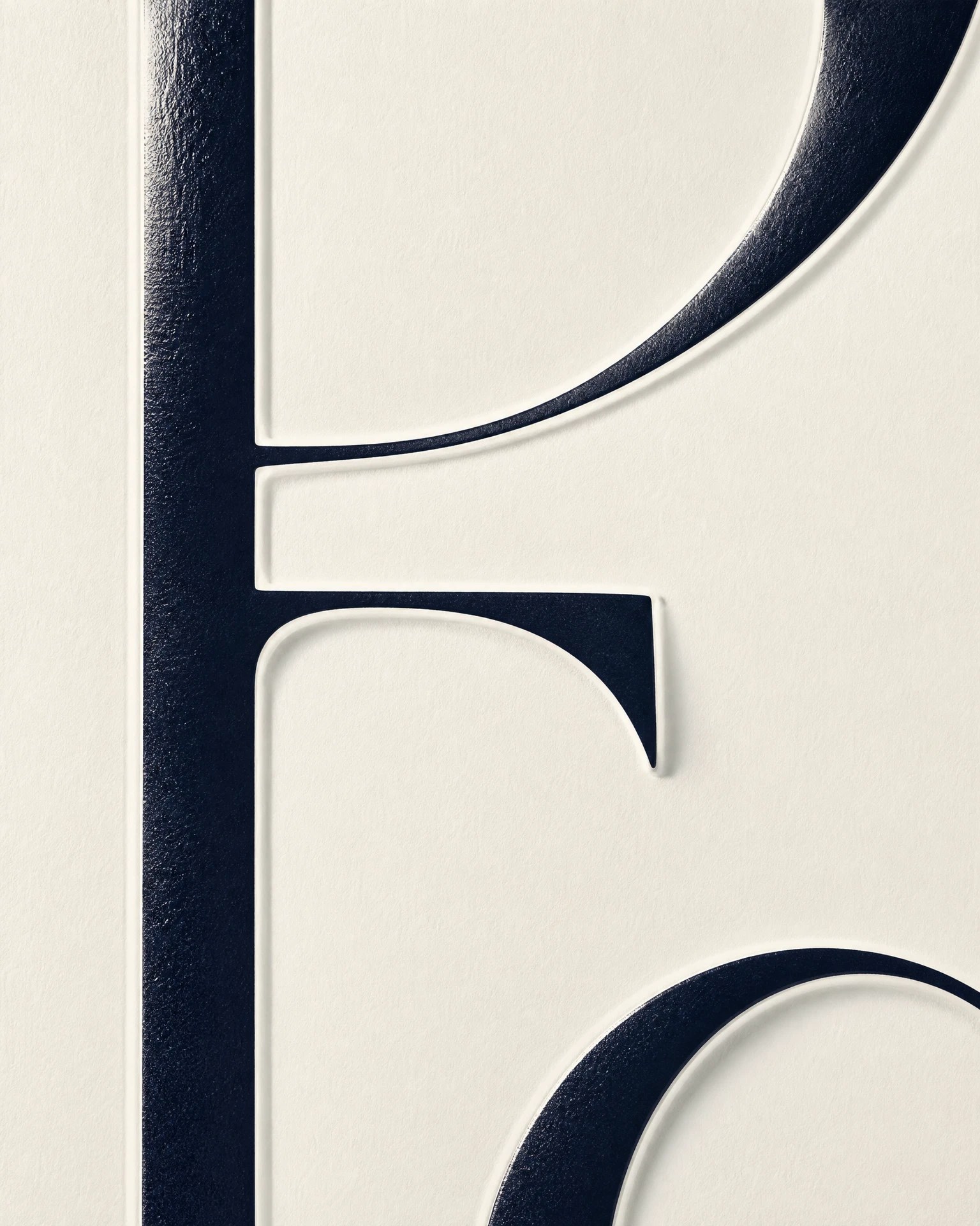 Abstract embossed serif letterform on mother-of-pearl ivory